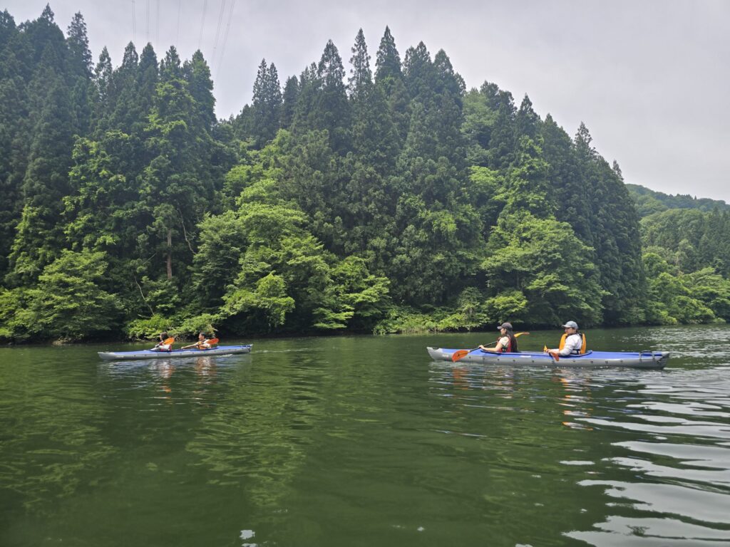 只見川の深い緑の中を進む2艇のカヤック