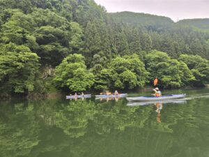 只見川を進む3艇のカヤックと山あいの鏡面反射