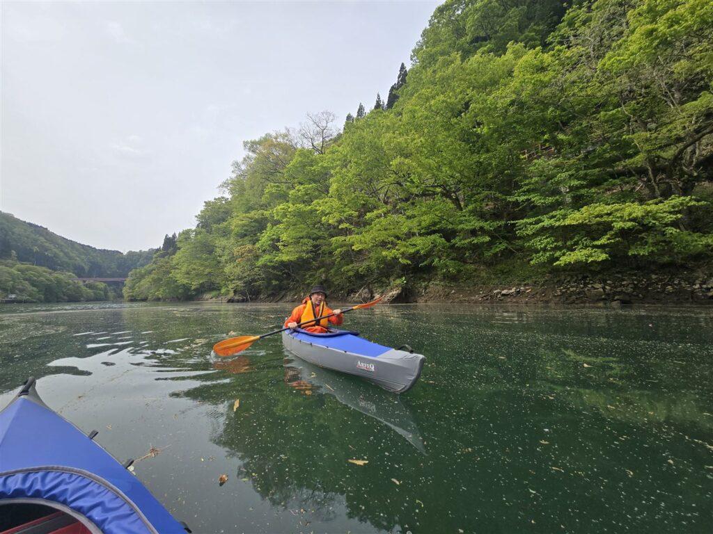 橋を背景に笑顔でパドリングするAさん