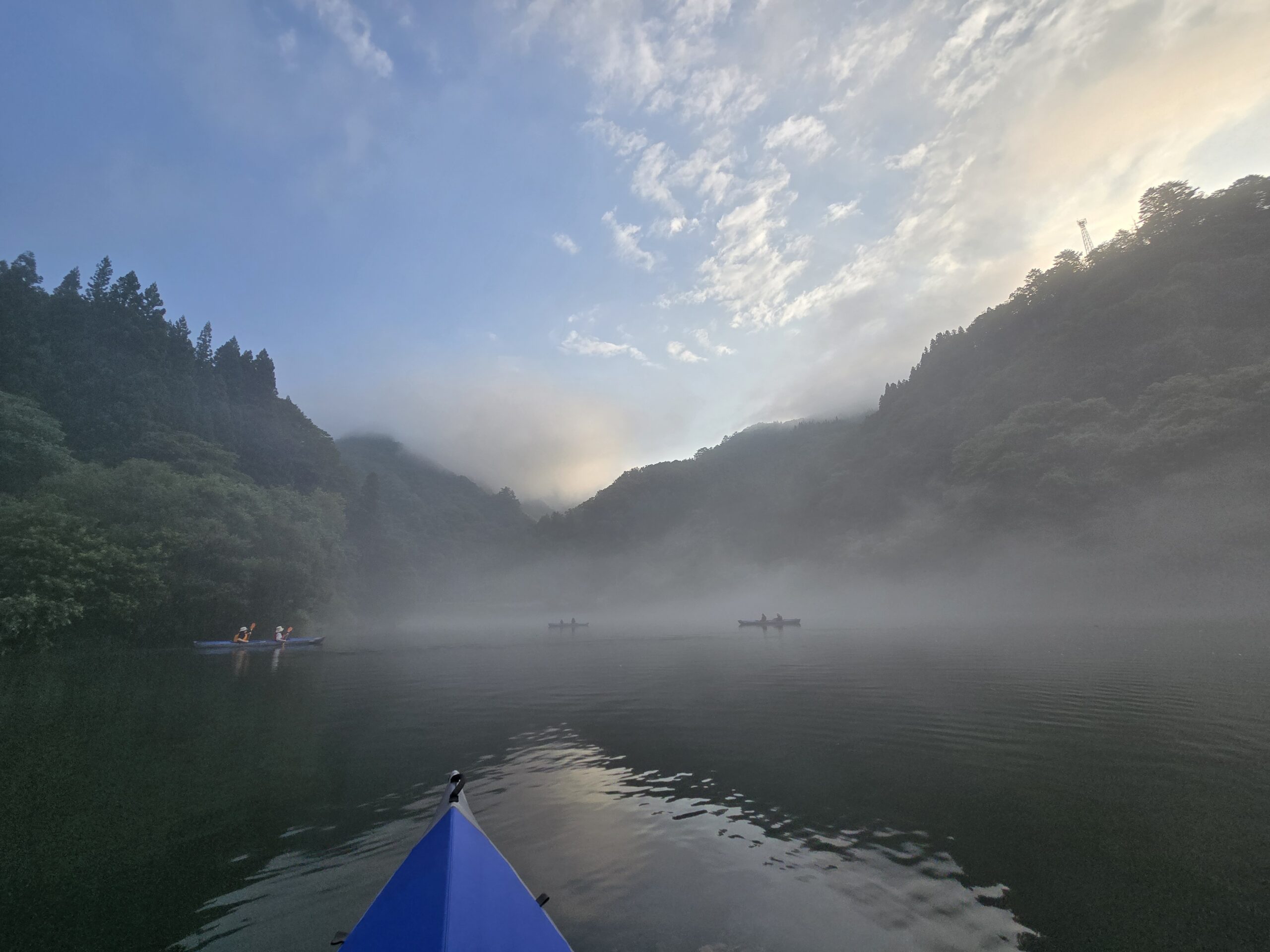 朝霧の中、複数艇で霧幻峡カヤックツアーを進む参加者たち