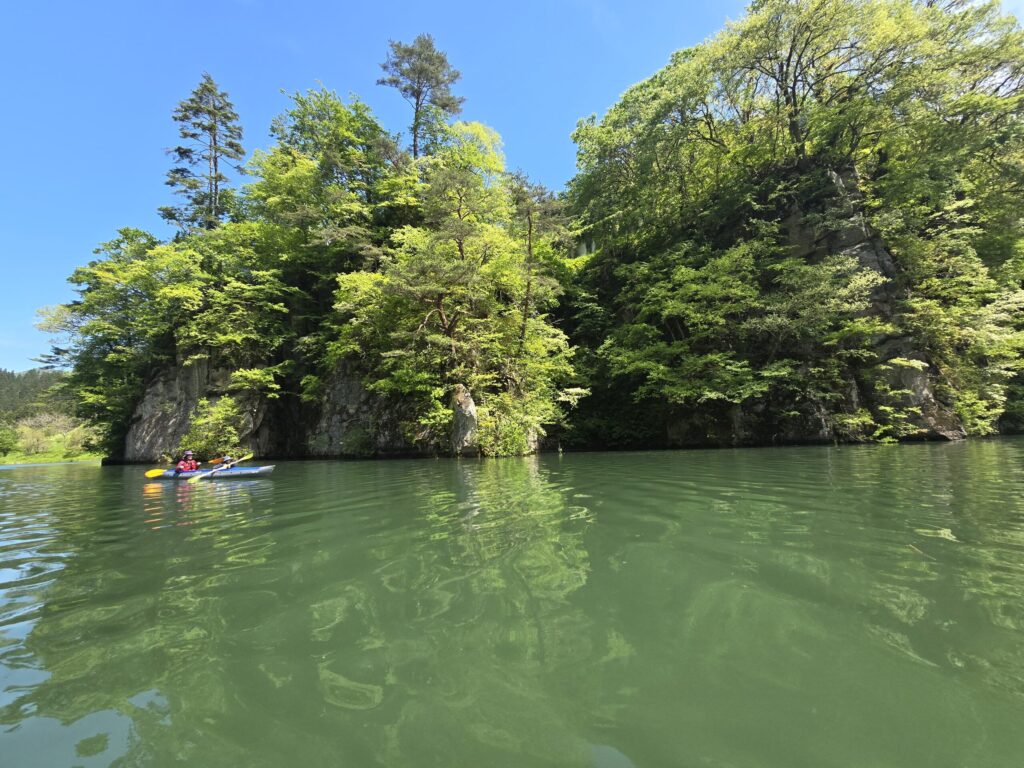 霧幻峡の岩壁沿いを進むカヤック