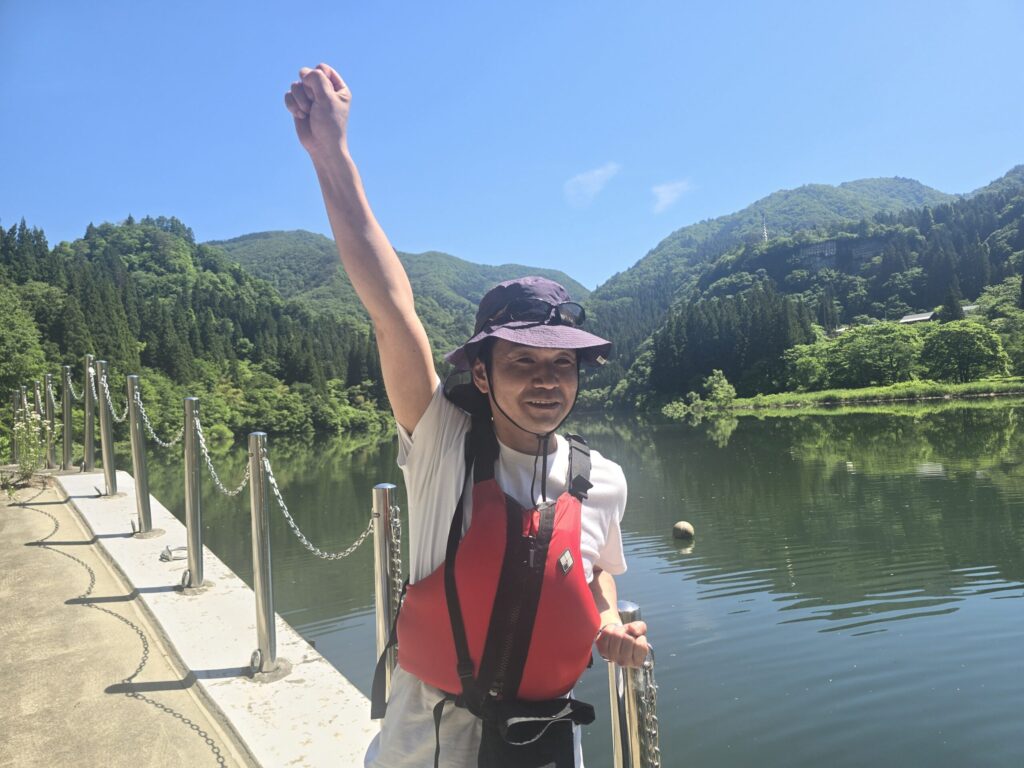 只見川の船着場でガッツポーズをするNさん