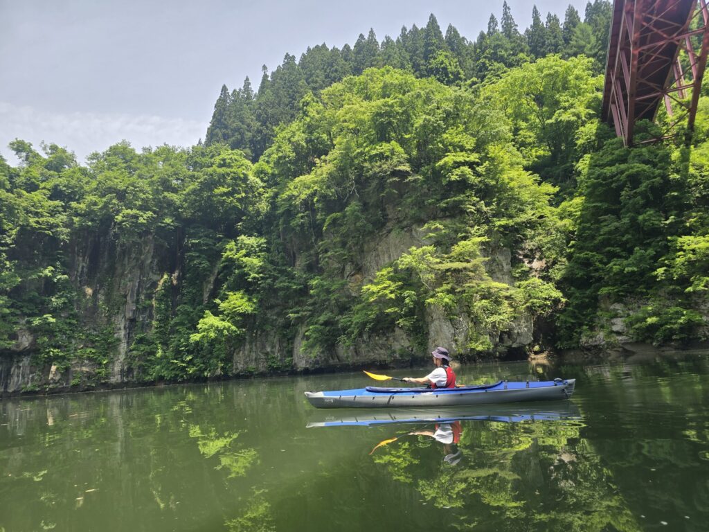 鉄橋を背景に只見川を進むカヤック