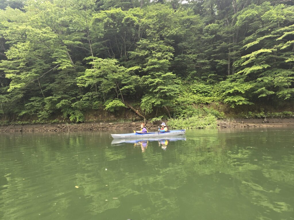 経験者の参加者が只見川で一人乗りカヤックを操る様子、霧幻峡カヤックツアー