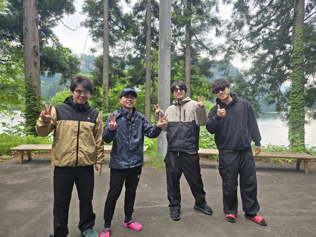 朝涼み霧幻峡カヤックツアー出発前の集合写真、只見川と新緑を背景に4名の参加者
