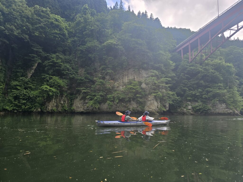 朝霧に包まれた只見川と橋を進むカヤック