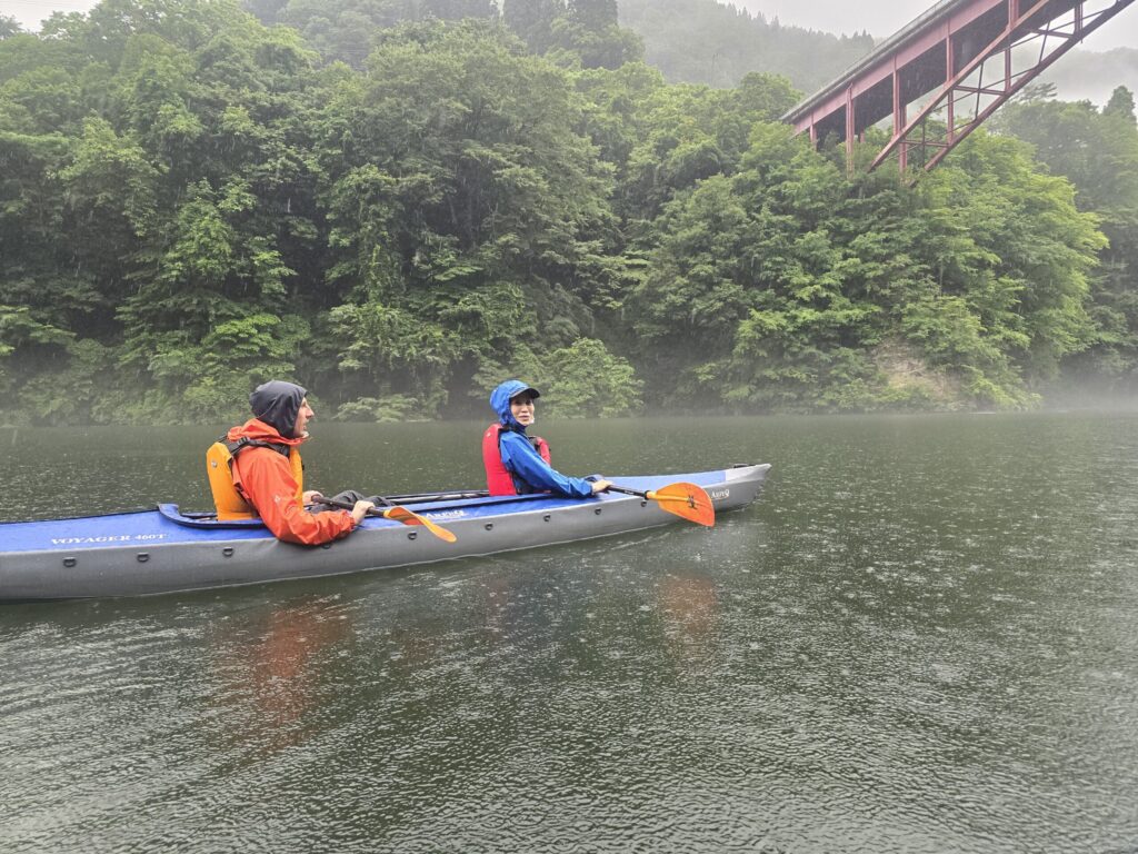 只見線の鉄橋を背景に只見川を進むカヤック