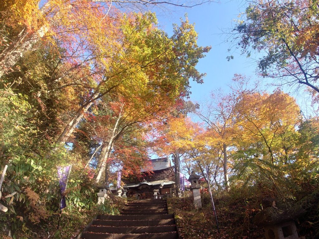 柳津町・福満虚空藏菩薩圓藏寺の参道の石段。社殿を赤や黄に色づいた木々が囲む